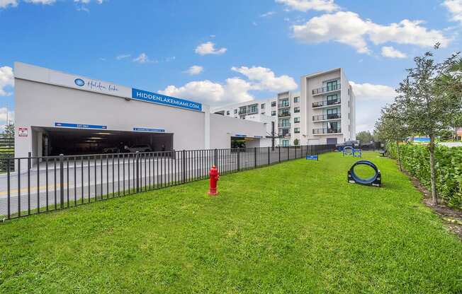 A grassy area with a fire hydrant in front of a building