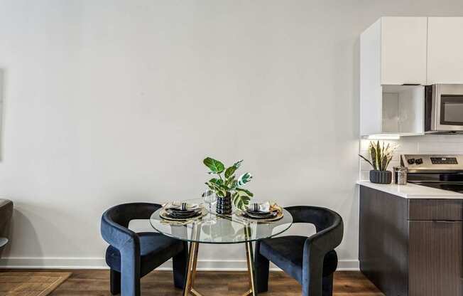 A modern dining area with a glass table and blue chairs.