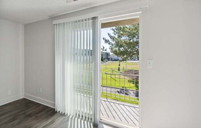 A room with a sliding door leading to a backyard.