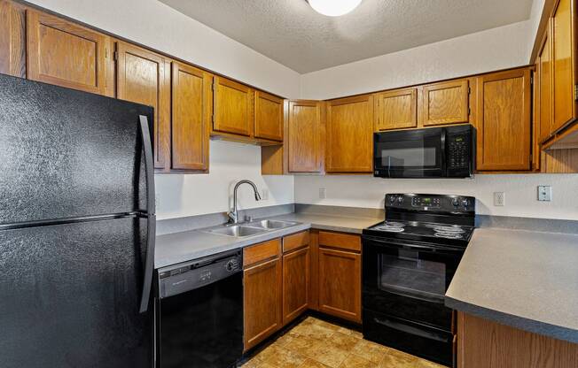 a kitchen with black appliances and wood cabinets