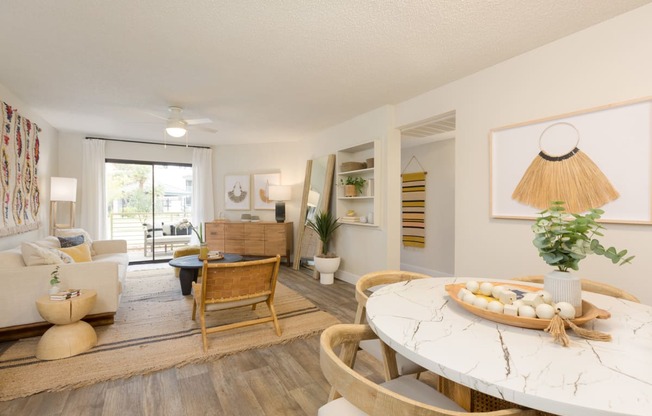 a living room with a white table and chairs and a sliding glass door leading to a patio