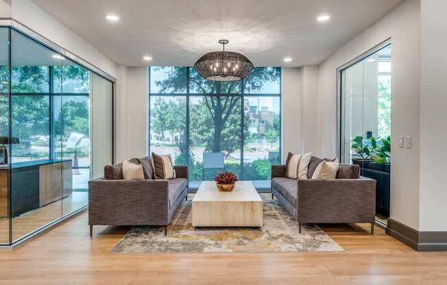 a living room with couches and a coffee table in front of large windows