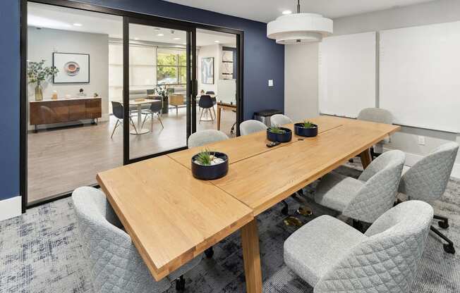 A conference room with a long table and grey chairs at The Kitt at Warner Center Apartments, Woodland Hills 91303