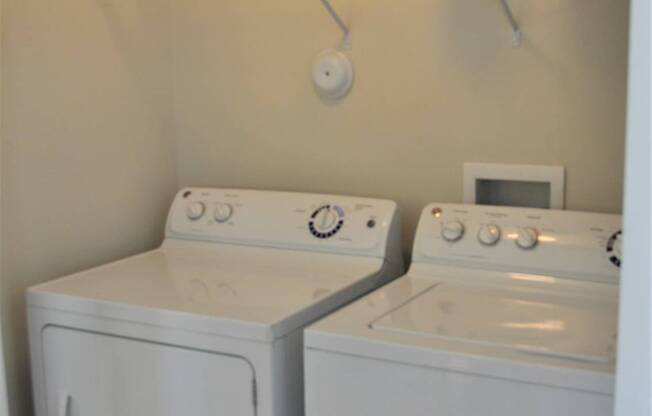 A small laundry room with a washer and dryer.