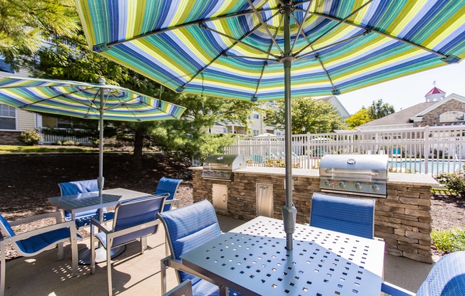 Outdoor dining with umbrella shaded tables at  Fieldstone Farm apartments for Rent in Odenton, MD