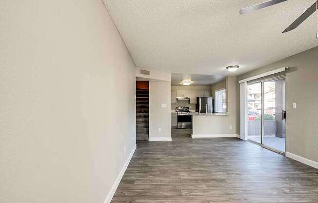 A spacious room with a ceiling fan and a kitchen area in the background at Sterling Point Apartment Homes, Arizona, 85042