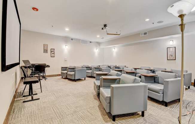 our theater room with couches and chairs and a piano