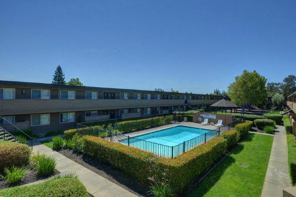 Outdoor Swimming Pool, Apartment Exteriors,Grass, and Bushes