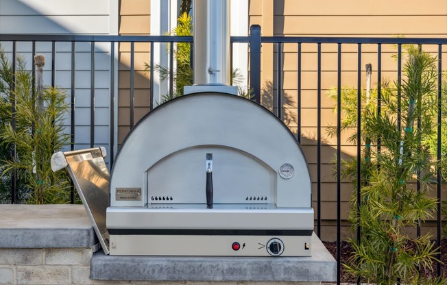 a silver domed oven sitting on a curb in front of a house