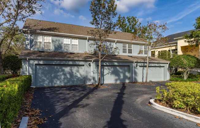 A house with a grey garage door and a driveway.