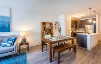 a living room and dining room with a wooden table