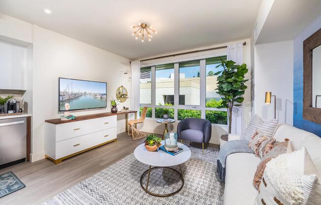Open‑concept living area with oversized windows bringing in abundant natural light.