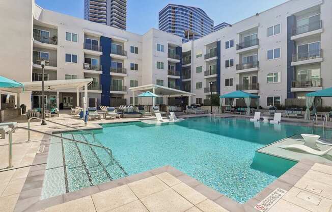 A large swimming pool surrounded by apartment buildings.