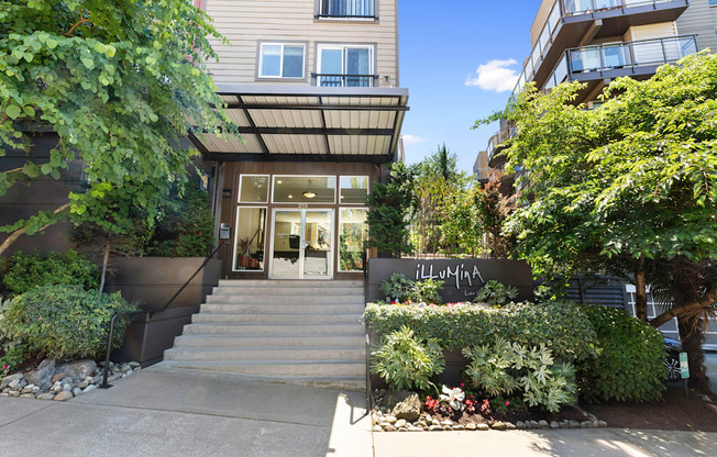 the front of the property building with stairs and bushes in front of it at Illumina Apartment Homes, Seattle