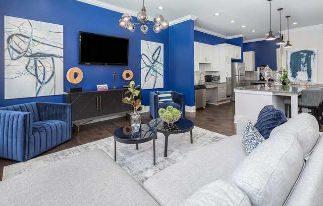 A modern living room with a grey sofa and a blue accent wall.