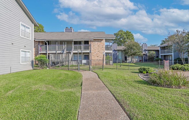 Walkway toward our beautiful apartments on a sunny day with a clear sky at Laurel Parc apartments in Shreveport, LA.
