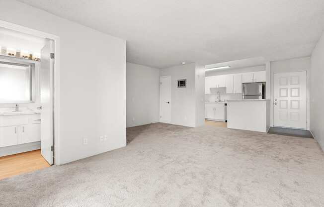 A large, empty room with a carpeted floor and white walls.