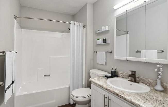 Model Bathroom with White Cabinets, Wood-Style Flooring and Shower/Tub at Overlook Point Apartments in Salt Lake City, UT.