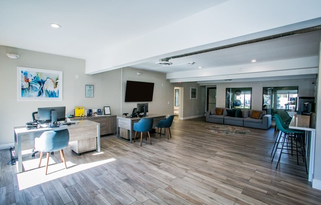 a living room with a desk and chairs and a couch