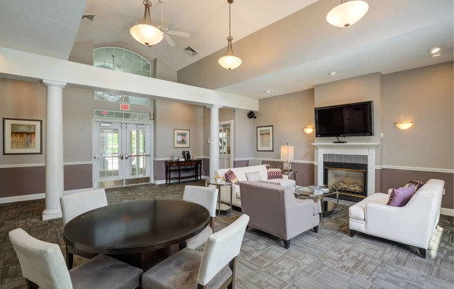 a living room with couches chairs and a table and a fireplace