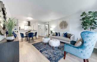 a living room with a couch and chairs and a dining table