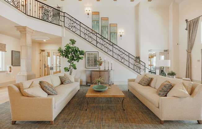 A living room with two couches, a coffee table, and a staircase.
