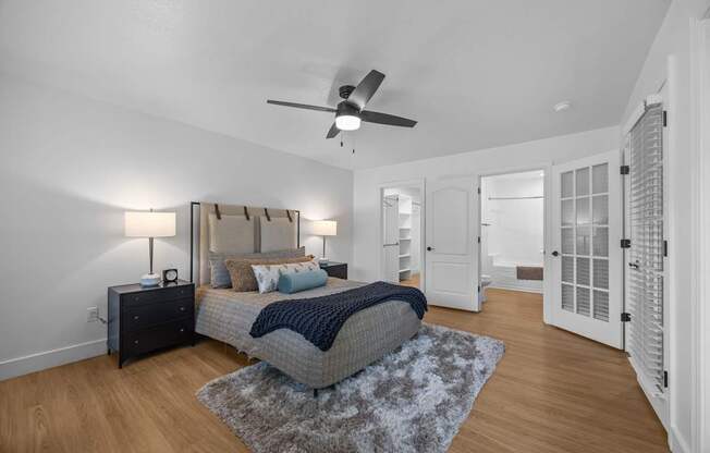 A bedroom with a bed, dresser, and ceiling fan.