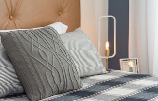 a bedroom with a bed with two pillows and a lamp on the side of the bed at The Bend Arbordale, Williamsburg, 23188