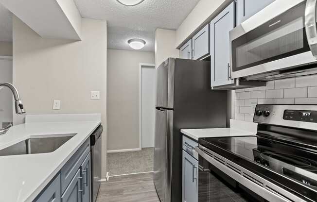 a kitchen with stainless steel appliances and white counter tops at Trails at Short Pump Apartments, Richmond, VA, 23233