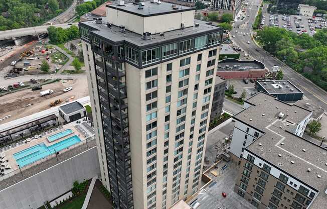 a tall building with many windows and a blue pool in front of it
