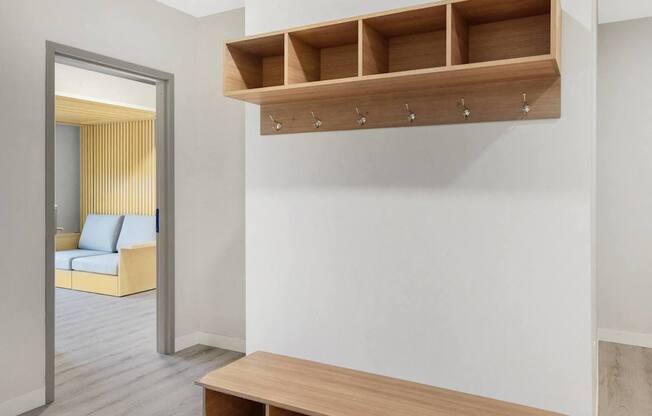 A room with a white wall and a wooden bench with drawers underneath it.