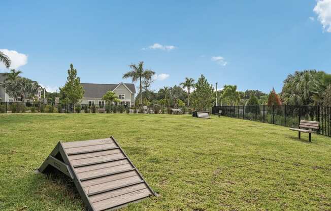 a park with a picnic table and benches in the grass at Palm Grove in Ellenton, FL 34222