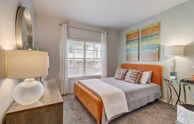 a bedroom with a bed and a desk and a window