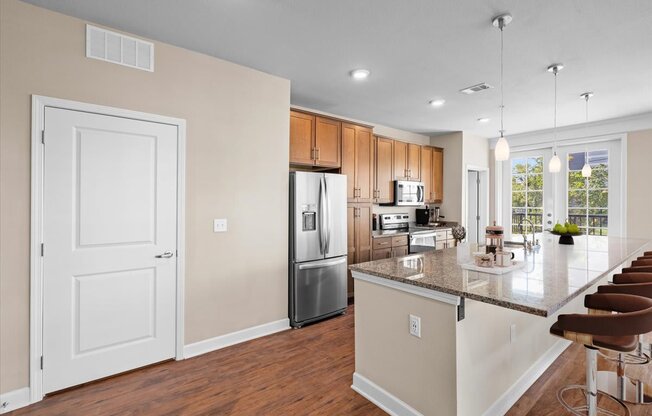 a kitchen with a large island and stainless steel appliances