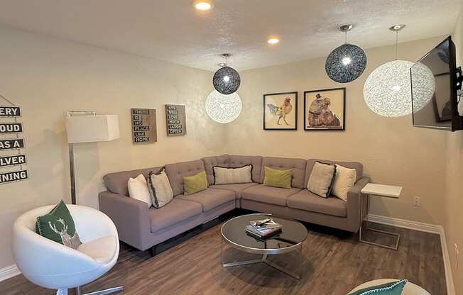 A living room with a grey couch, a white chair and a coffee table.
