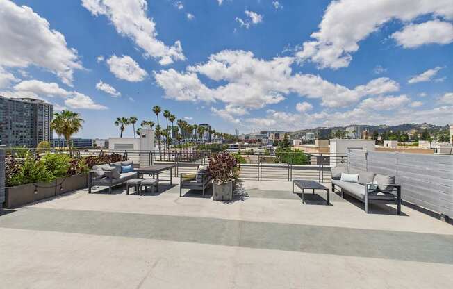 A rooftop patio with a couch, chairs, and a table.