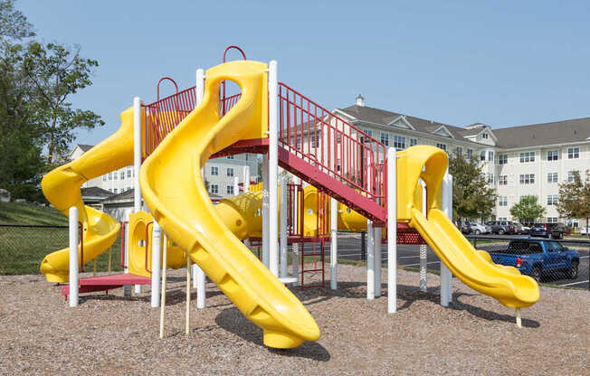 Playground with Multiple Slides and Activities on Mulch Bed | Canton Woods apartments in MA