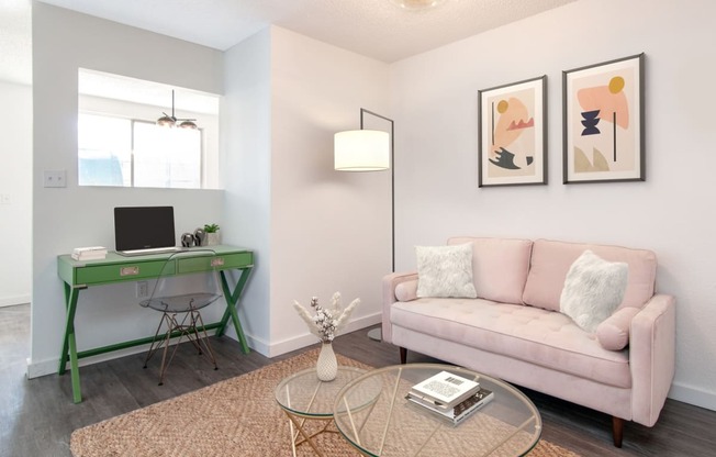 a living room with a green desk and a pink couch