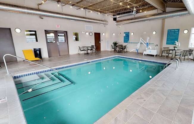 a large indoor swimming pool with chairs and tables