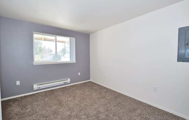 an empty room with a window and a radiator