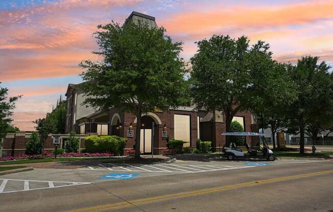 A parking lot with a golf cart and a building in the background.