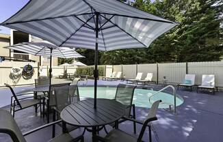Unique Swimming Pool with Table, Chairs, and Umbrella for Relaxing in the Shade at Park 210 Apartment Homes, Washington
