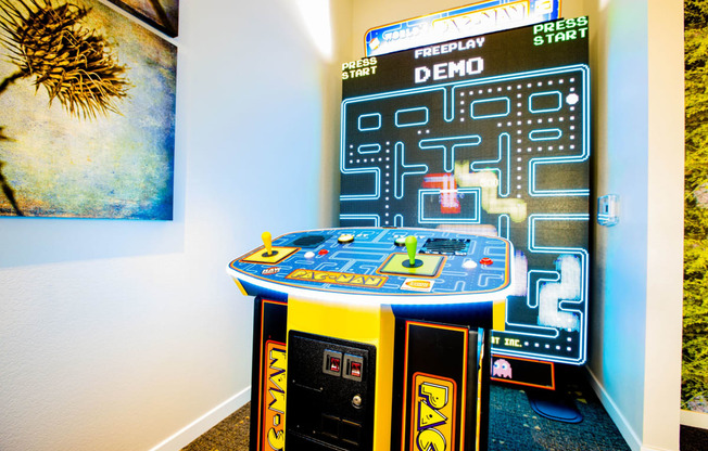 an arcade game in a room with a poster on the wall