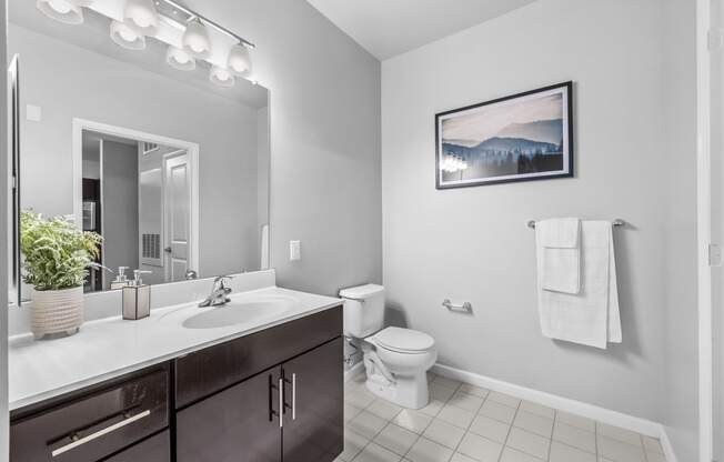 a bathroom with a toilet sink and mirror  at Harbor Pointe, Bayonne, New Jersey