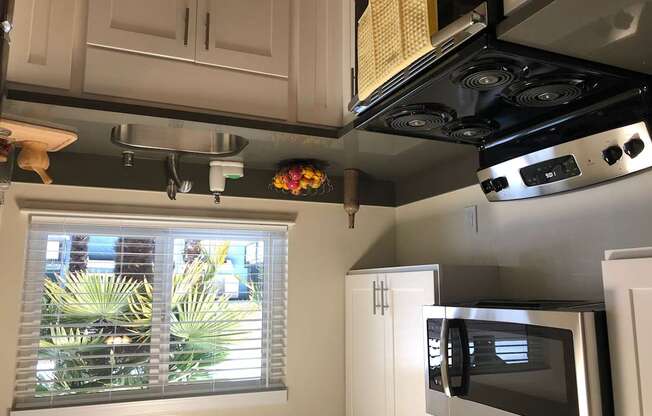 a kitchen with a window and a stove and a microwave