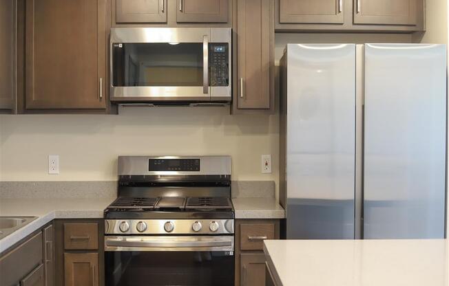 a kitchen with a stove refrigerator and microwave at Loma Villas Apartments, San Bernardino California