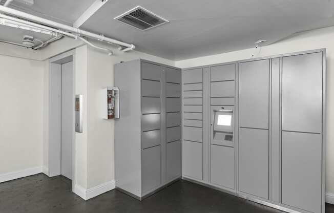 a row of gray lockers in a room with a white wall