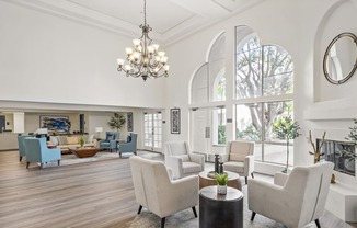 a living room with white furniture and large windows