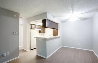 A kitchen area with a white counter and a refrigerator.