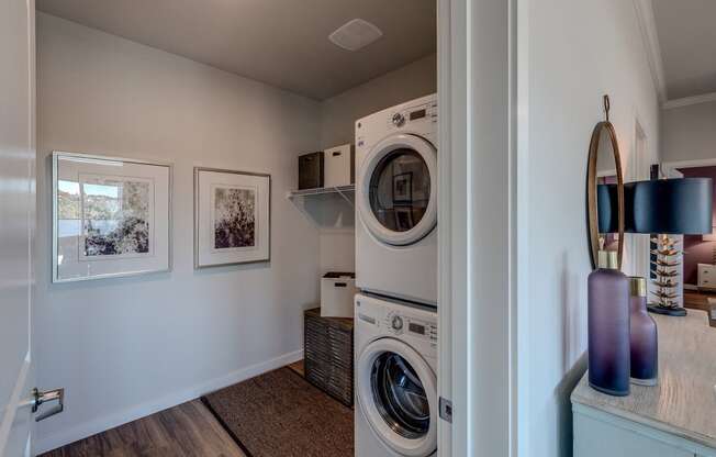 Lux Apartments Bellevue WA in-unit laundry room with front loading washer and dryer and additional storage space.